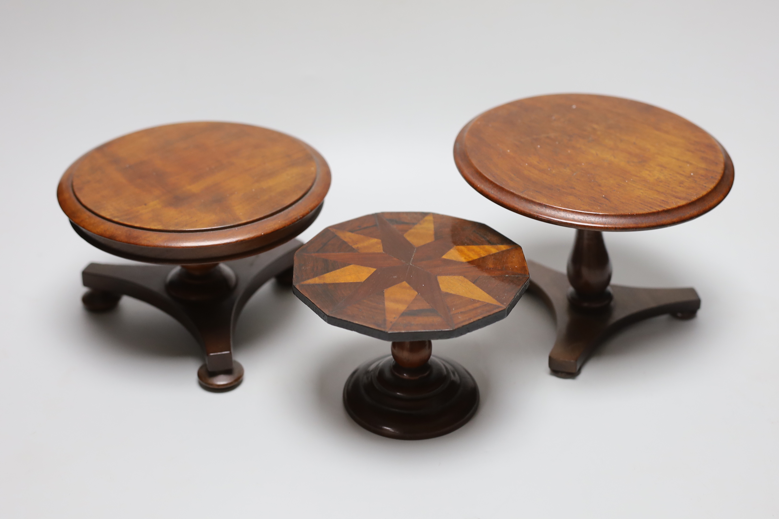 Three 19th century apprentice miniature table or doll’s house furniture; parquetry and two tripod tables, tallest 14cm